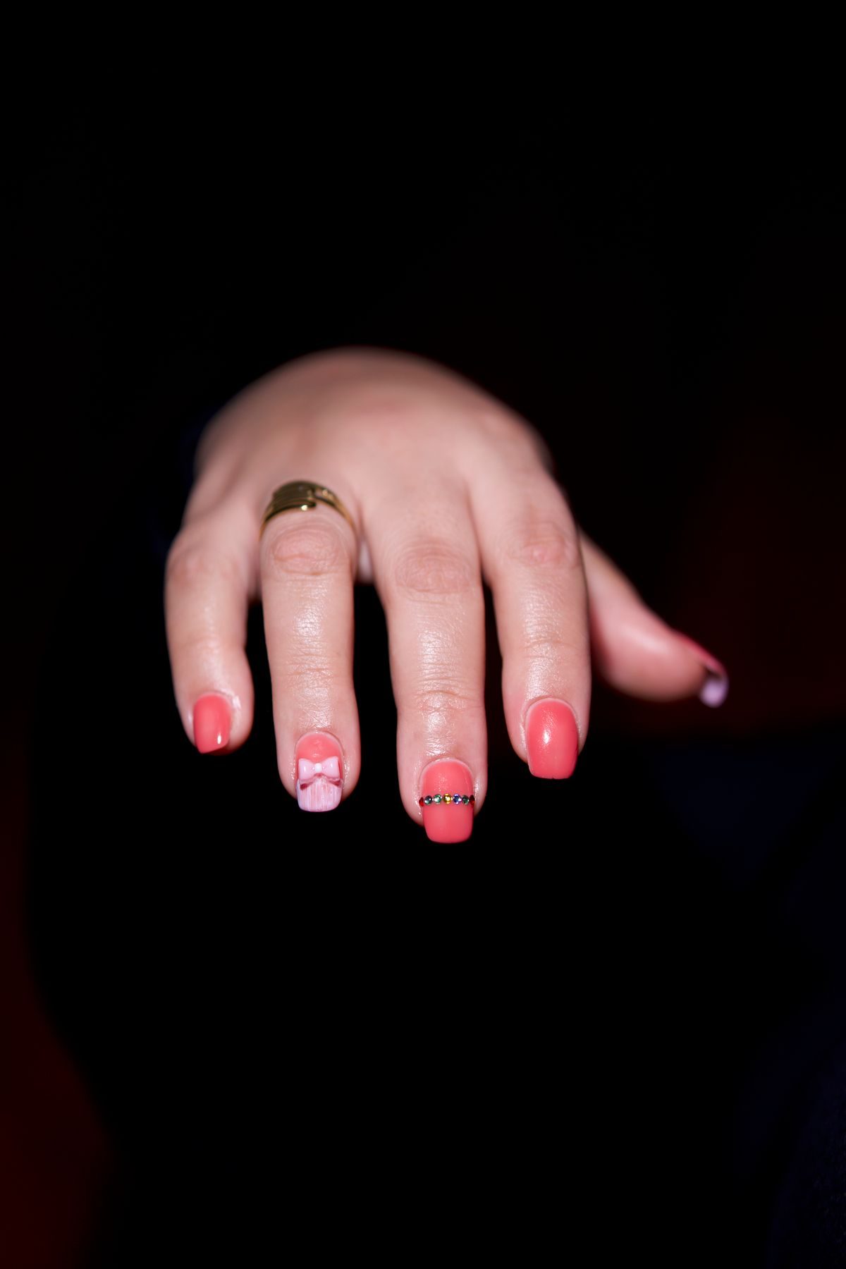 Pink nail art with a gold ring